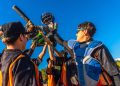 L'immagine mostra alcuni giovani di una squadra di baseball che festeggiano una vittoria alzando le mazze e i caschi