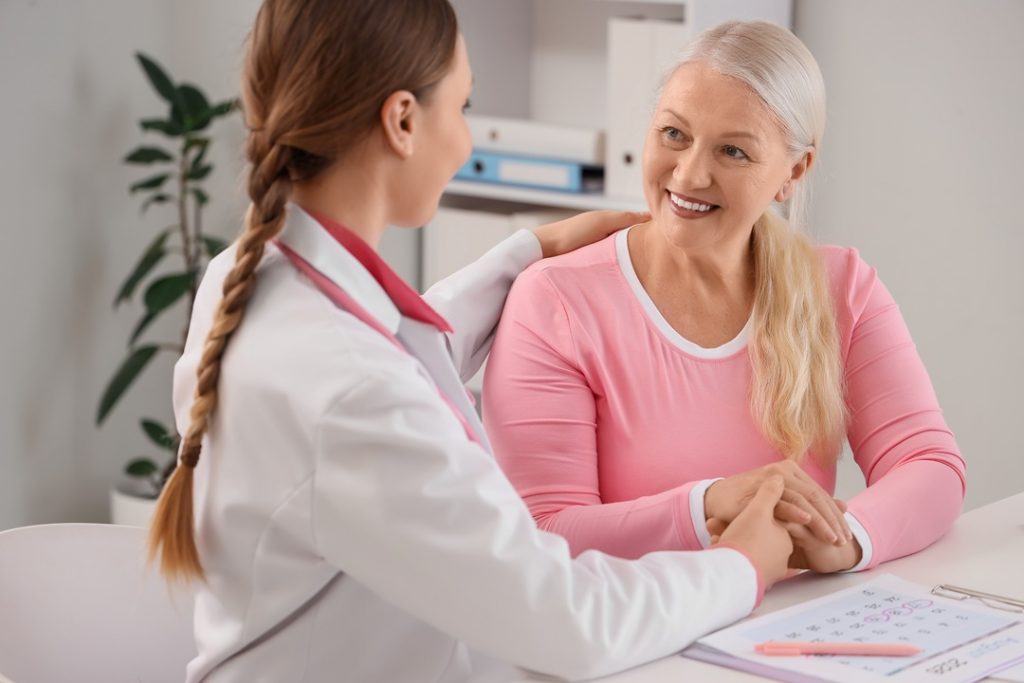 L'immagine mostra una donna anziana che trova conforto da una dottoressa. Immagine utilizzata per Nuovo servizio menopausa dell'ospedale Del Ponte di Varese _Shutterstock 050826