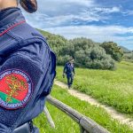 Carabinieri forestali, forestale. L'immagine mostra la divisa di un carabiniere in primo piano e, in secondo piano, un collega che cammina su un sentiero. Utilizzata per notizia incendio Ticino _Immagine sito Carabinieri