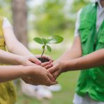 Il bando di Regione Lombardia per promuovere l'Educazione ambientale. La foto mostra tre bambini con le mani unite che stringono una manciata di terra con un germoglio _Shutterstock 01092026
