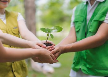 Il bando di Regione Lombardia per promuovere l'Educazione alla sostenibilità. La foto mostra tre bambini con le mani unite che stringono una manciata di terra con un germoglio _Shutterstock 01092026