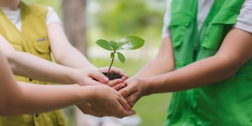 Il bando di Regione Lombardia per promuovere l'Educazione alla sostenibilità. La foto mostra tre bambini con le mani unite che stringono una manciata di terra con un germoglio _Shutterstock 01092026