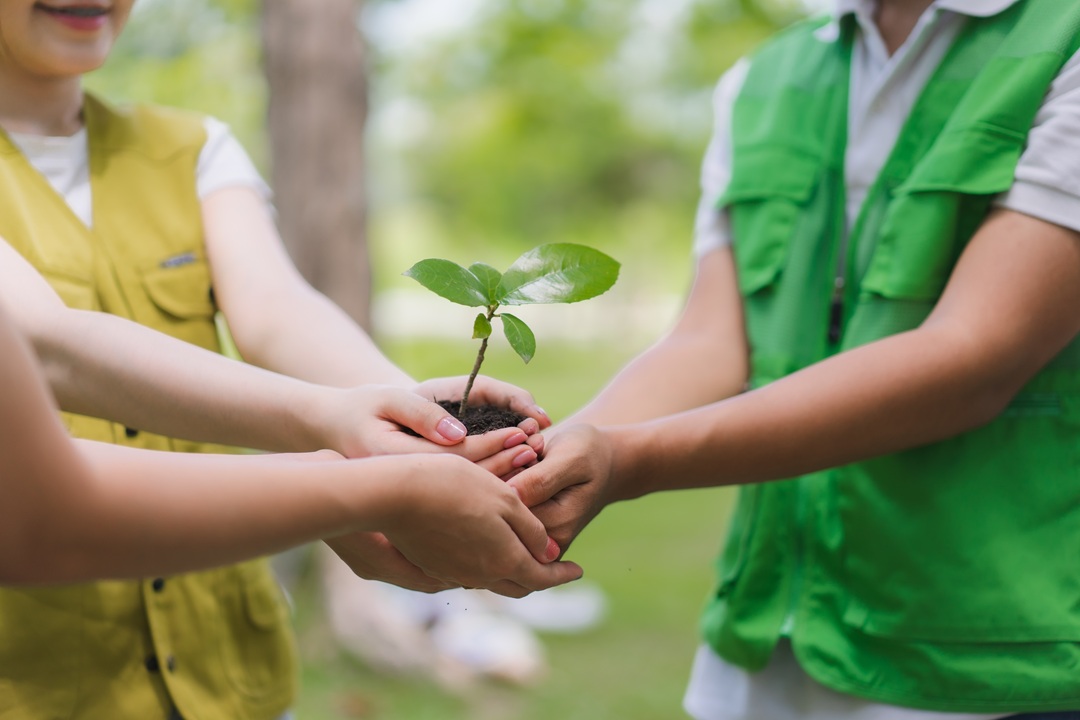 Il bando di Regione Lombardia per promuovere l'Educazione alla sostenibilità. La foto mostra tre bambini con le mani unite che stringono una manciata di terra con un germoglio _Shutterstock 01092026