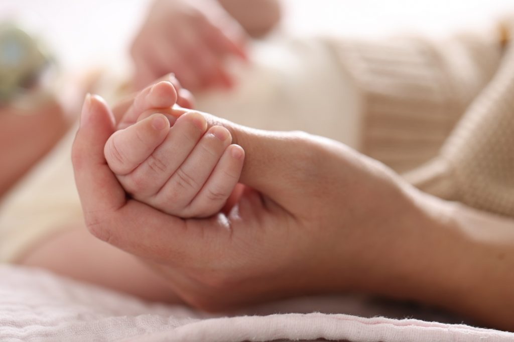 La foto mostra una mano che stringe la manina di un neonato. Foto utilizzata per campagna immunizzazione Regione Lombardia contro il virus respiratorio sinciziale