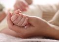 La foto mostra una mano che stringe la manina di un neonato. Foto utilizzata per campagna immunizzazione Regione Lombardia contro il virus respiratorio sinciziale