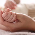 La foto mostra una mano che stringe la manina di un neonato. Foto utilizzata per campagna immunizzazione Regione Lombardia contro il virus respiratorio sinciziale