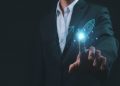 L'immagine mostra un uomo in abito da lavoro nello sfondo e in primo piano una mano che 'clicca' su un razzo grafico, dando l'idea di dare un'accelerata alla sua azienda. Utilizzata per illustrare la presentazione del progetto Pianeta Accelerator per le startup di Regione Lombardia