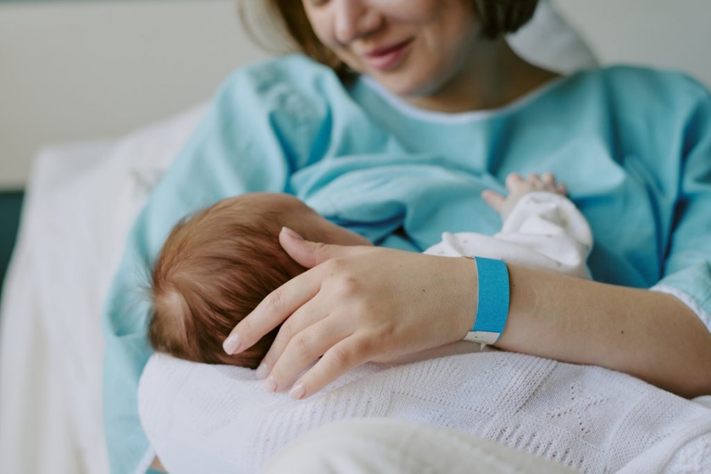 Mamma con in braccio un neonato in ospedale. Immagine utilizzata per picco nascite sant'Anna di Como