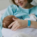 Mamma con in braccio un neonato in ospedale. Immagine utilizzata per picco nascite sant'Anna di Como