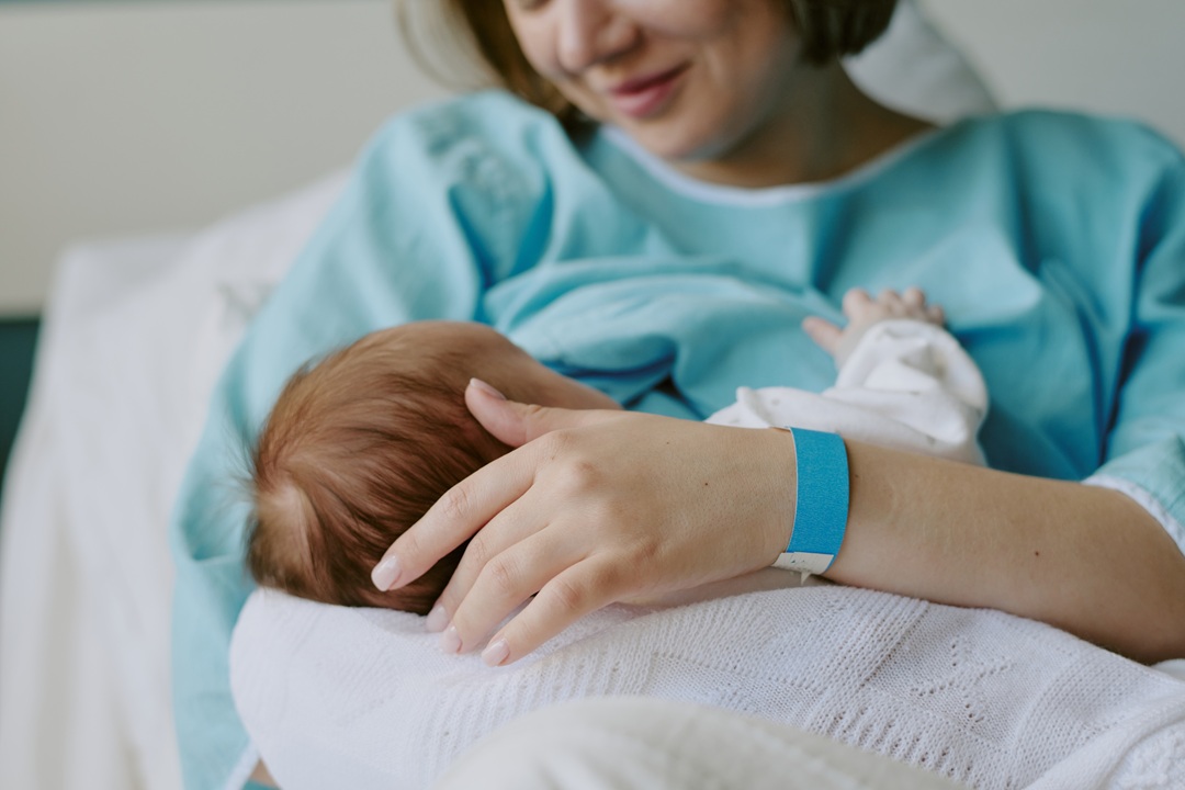 Mamma con in braccio un neonato in ospedale. Immagine utilizzata per picco nascite sant'Anna di Como